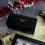 Caixa preta para lenha de Natal com inscrição dourada "Boas Festas"
